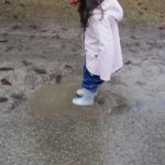 Little Girl Playing in a Puddle