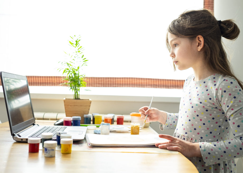 Distance education concept. Covid lockdown. Caucasian girl learns to draw online during self-isolation.