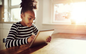 Young black girl browsing on a tablet-pc