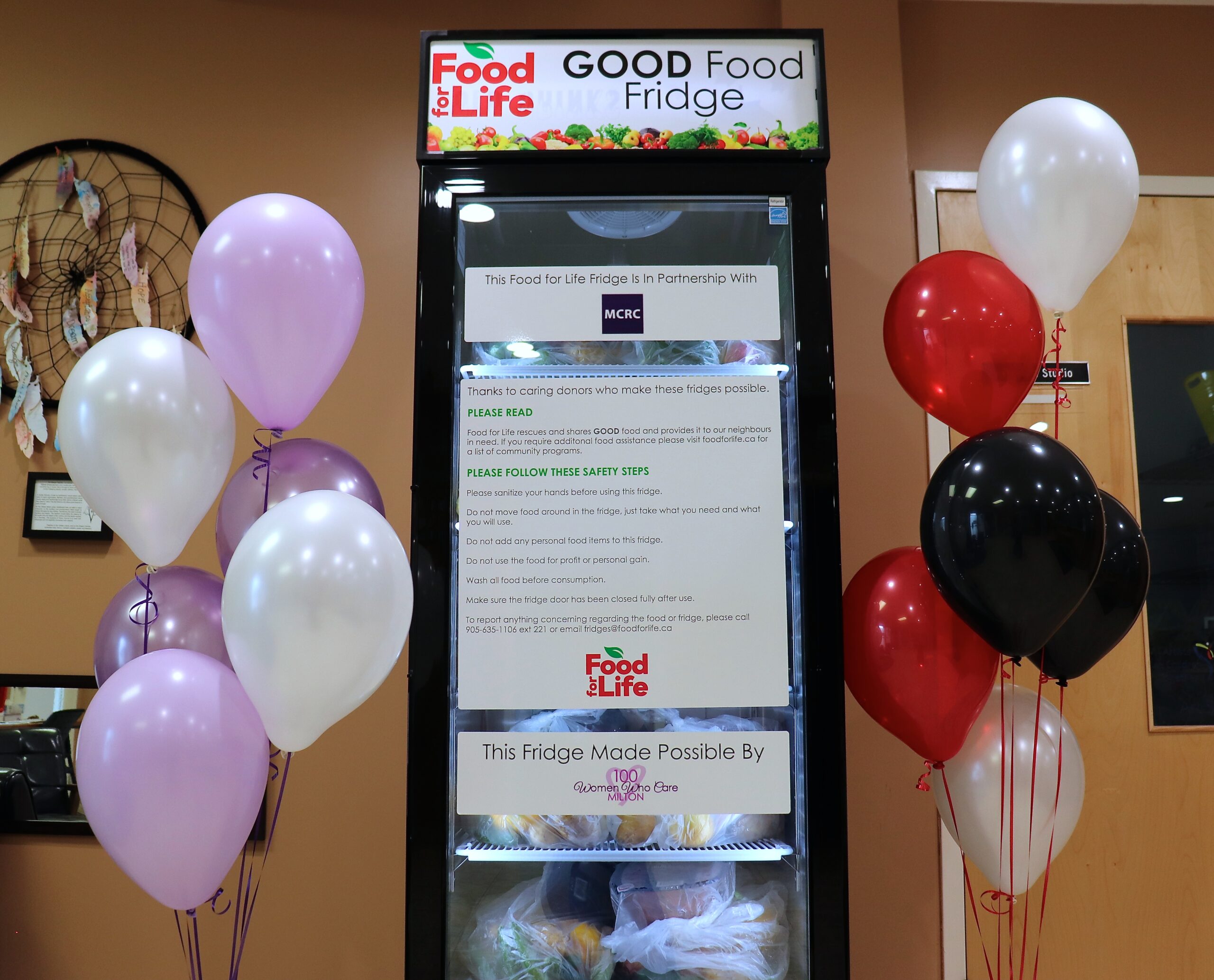 Photo of full GOOD Food Fridge in the lobby of MCRC with balloons on either side