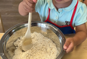 a child mixing dry ingredients in a bowl