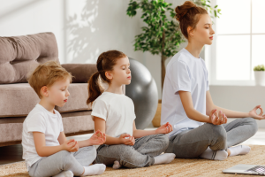 two toddlers and a parent doing yoga together