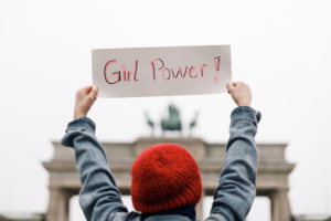 person holding up a sign that reads girl power!