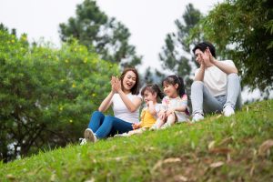 young family sitting in grass