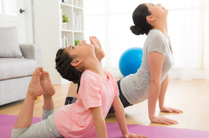 child and parent doing yoga together