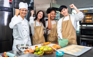 A group of teens standing together in a kitchen