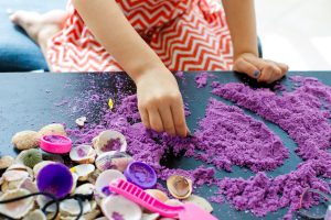 girl playing with purple sand