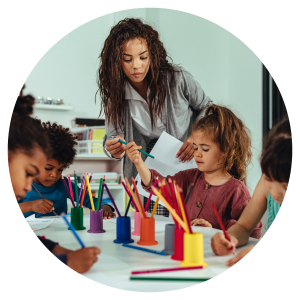 a woman in a room of children doing an activity at a table