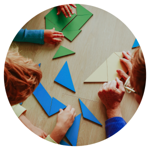 children's hands playing with different coloured shapes on a table