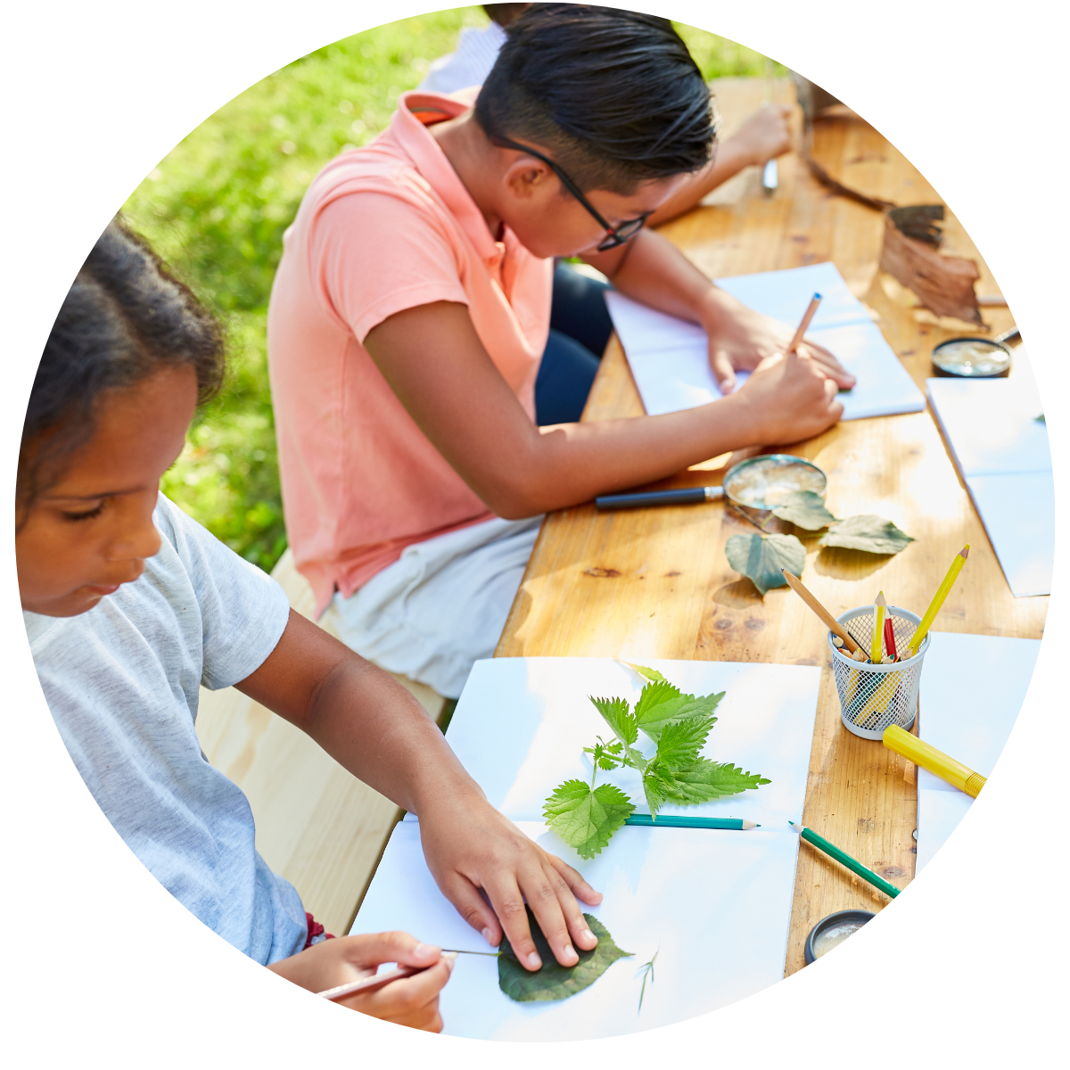 photo of kids doing a leaf tracing art activity in an outdoor setting