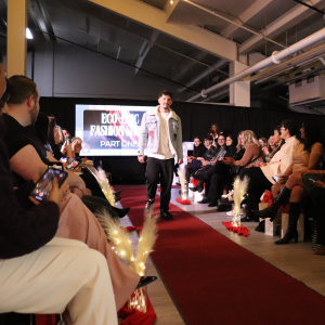 a male model walking the run way at eco-chic 2025