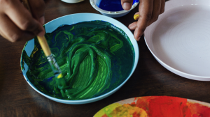 A brush in a bowl of green paint