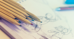 pencils stacked on a notebook with an illustration