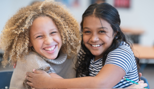 two girls hugging and smiling